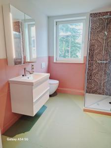 a bathroom with a sink and a toilet and a window at Villa Lebensgrund in Reichenbach im Vogtland +11 photos