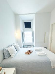 a white bedroom with a large bed with a tray on it at Room in the Heart of Historic Lisbon on Rua Augusta in Lisbon