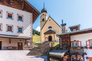 un edificio con una scala che porta a una chiesa di Appartamenti Césa Col De Pin a Canazei