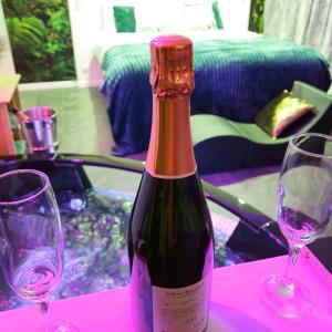 a bottle of wine sitting on a table with two glasses at Loveroom & Jacuzzi TIJUGO - Clermont Ferrand in Clermont-Ferrand +17 photos