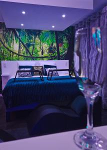 a bedroom with a bed and a wine glass at Loveroom & Jacuzzi TIJUGO - Clermont Ferrand in Clermont-Ferrand
