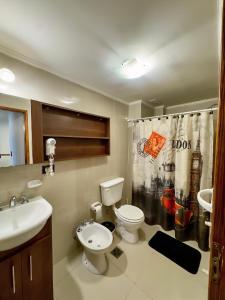 Un baño con inodoro, lavabo y cortina de ducha. en MIRALEJOs, en Villa Carlos Paz