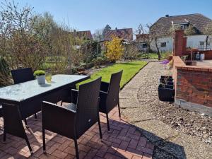 eine Terrasse mit einem Tisch und Stühlen im Hinterhof in der Unterkunft Wohnung Goldblick in Teschendorf