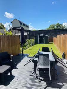 a patio with a table and chairs and an umbrella at La Risloise in Pont-Audemer