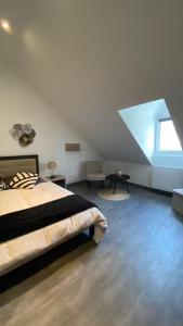 a white room with a bed and a window at La Risloise in Pont-Audemer