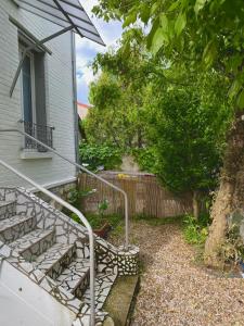 a set of stairs leading to a house with a tree at Maison avec jardin située à 15mn de Paris centre in Créteil +2 photos