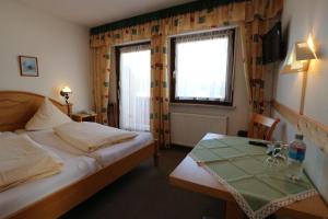 WittenschwandにあるHotel Dachsberger-Hofのベッドとテーブルが備わるホテルルームです。