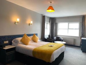 a hotel room with a large bed with yellow sheets at The Donard in Newcastle
