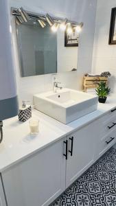 ein weißes Badezimmer mit Waschbecken und Spiegel in der Unterkunft Casa da Marina in Angra do Heroísmo