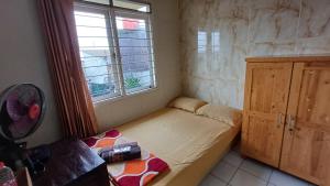 a small bedroom with a bed and a window at Kost Carmelia Syariah Baranangsiang Bogor in Bogor