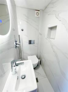 a white bathroom with a sink and a toilet at The Little Prince in Petra