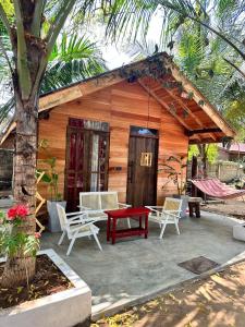 a small wooden cabin with a red table and chairs at Swiss kiss beach resort in Uppuveli +75 photos