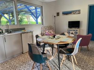 a living room with a table and chairs and a kitchen at Peaceful home amongst olive groves by the sea in Koroni