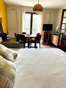 een slaapkamer met een bed, een tafel en stoelen bij CASA D'IRENE Havre de paix cosy romantique proche des châteaux de la Loire et a proximité du Parc de Beauval in Mareuil-sur-Cher
