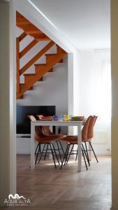 una sala da pranzo con tavolo e sedie sotto una scala di Aqua Alta a Chioggia Altre 49 foto