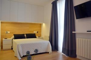 sypialnia z łóżkiem i dużym oknem w obiekcie Apartamentos Córdoba Atrium w Kordobie