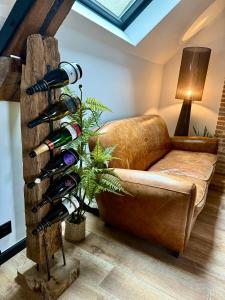 een kamer met een bank en een bos wijnflessen bij L'Evidence, appartement authentique - Epernay in Épernay +29 foto's