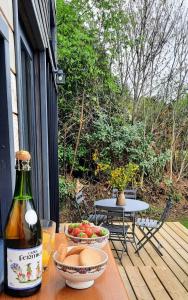 a table with a bottle of wine and a bowl of fruit at My Tiny House proche mer in Clohars-Fouesnant +8 photos