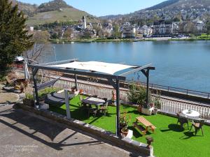a gazebo with a table and benches and a lake at Klein aber fein in Alf