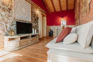 a living room with a couch and a tv at La Casina de Maxa in Suares