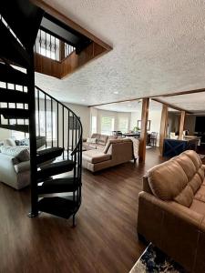a living room with a spiral staircase and a couch at Bay Street Blue Ludington Park in Escanaba