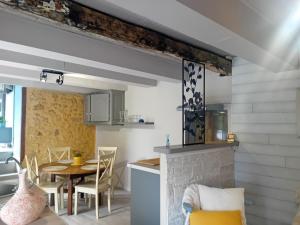 a kitchen and dining room with a table and a fireplace at Gite en Périgord in Doissat