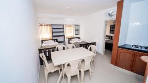 a dining room with two beds and a table and chairs at Hotel Chayrama in Santa Marta