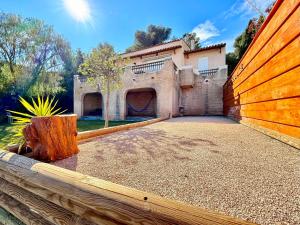 a house with a wooden fence in front of it at Superbe Villa vue mer - Jacuzzi - Pétanque in Carqueiranne