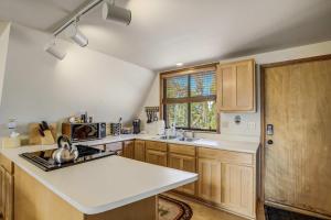 a kitchen with wooden cabinets and a white counter top at Slope Summit Rustic A-Frame Cabin w Scenic Views in Divide