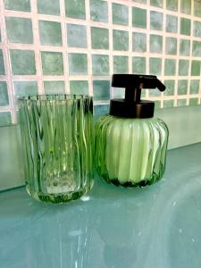 two green glass bottles sitting on top of a counter at PARADISE GARDEN in Los Alcázares