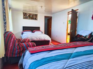 a bedroom with two beds and a door to a patio at Titicaca Perka Lodge in Puno