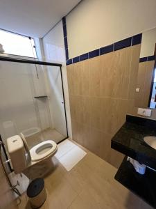 a bathroom with a toilet and a shower and a sink at Barra Hotel in Vargem Grande do Sul