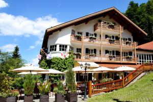 ein großes Gebäude mit Sonnenschirmen davor in der Unterkunft Berghotel Hammersbach in Grainau