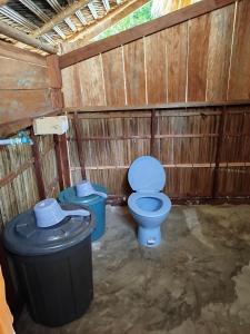 a bathroom with a toilet and a trash can at Batanta Panorama Homestay in Dayang