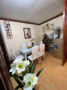 a kitchen and dining room with a table and white flowers at Golden Poppy Cozy Condo in Cebu City