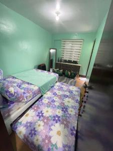 a bedroom with two beds with flowers on them at Golden Poppy Cozy Condo in Cebu City