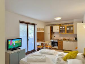 a room with a bed and a kitchen with a television at 1Dest - Casa Bont in Riva del Garda