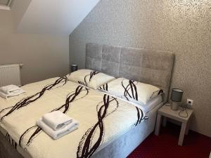a bedroom with a bed with towels on it at Penzión Grobský Dvor in Slovenský Grob