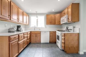 a kitchen with wooden cabinets and white appliances at 2 Miles to Coast Guard Beach in Eastham