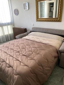 a large bed in a room with a mirror at Apartamento La Pineda a 100 metros de la playa!! in La Pineda