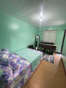 a bedroom with a bed and a dresser in it at Golden Poppy Cozy Condo in Cebu City