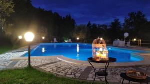 a bird cage sitting next to a swimming pool at night at ANIMA MUNDI case SULL'ALBERO in Pesco Sannita