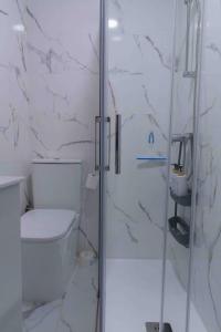 a bathroom with a toilet and a glass shower at Alojamiento Turístico García Pavón in Tomelloso +22 photos