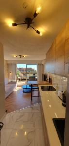 a kitchen with a ceiling fan and a living room at Architect's studio with pool, sea view and AC in Théoule-sur-Mer