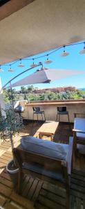 a patio with an umbrella and a table and chairs at Architect's studio with pool, sea view and AC in Théoule-sur-Mer