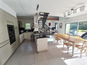 a kitchen and dining room with a table and chairs at Charme & Confort à Préfailles Piscine,Plage,Calme in Préfailles +14 photos