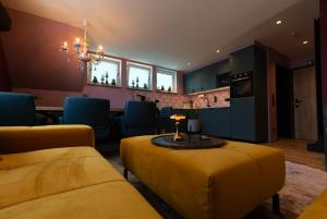 a living room with yellow furniture and a table at Boutique Apartments by Roy Oberhausen in Oberhausen