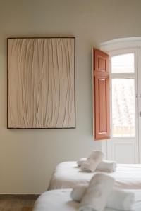 Dos camas en una habitación con un cuadro en la pared. en Cream Boutique Málaga, en Málaga
