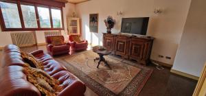 a living room with a leather couch and a television at Villa Brazil B&B in Lido di Jesolo