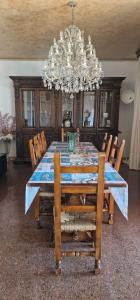 a dining room table with chairs and a chandelier at Villa Brazil B&B in Lido di Jesolo